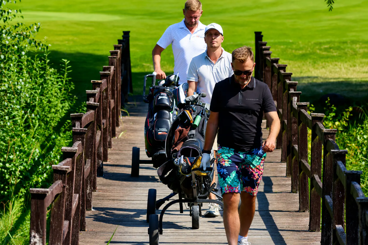 Golfeurs traversant une passerelle en bois à Binowo Park