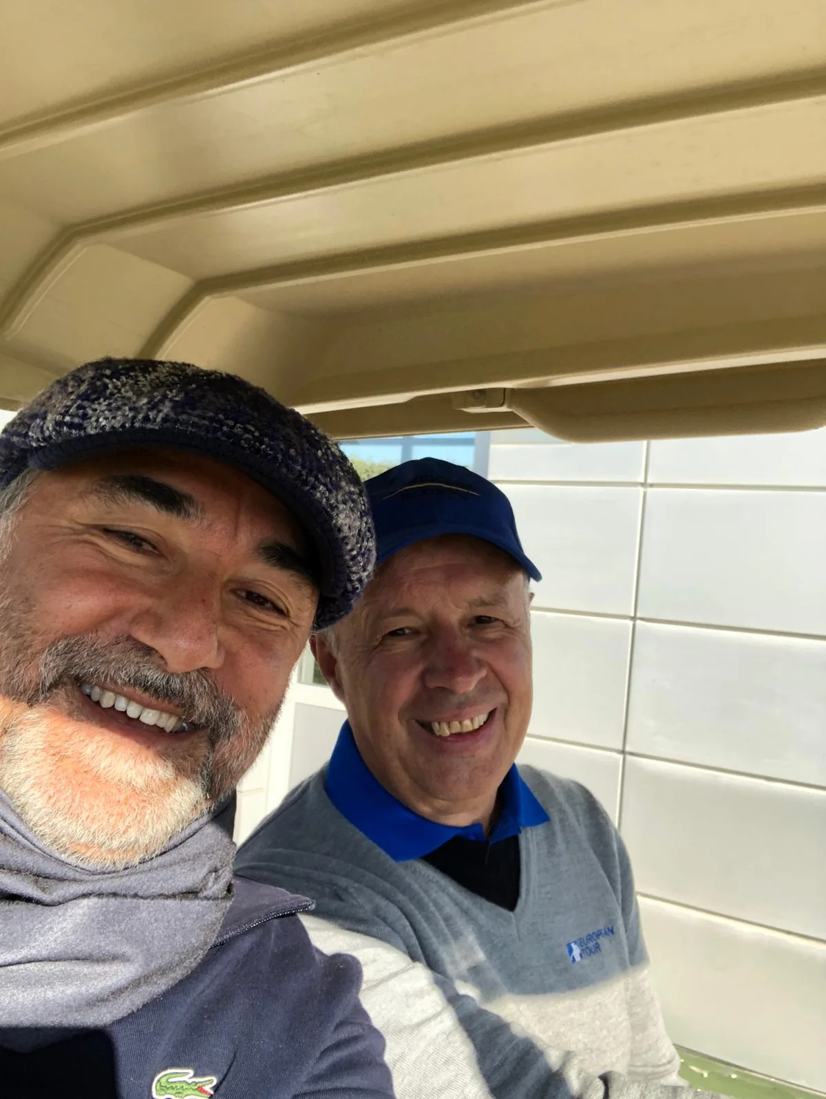 Eugen Mesares and Cahit Şahin smiling together in a golf cart